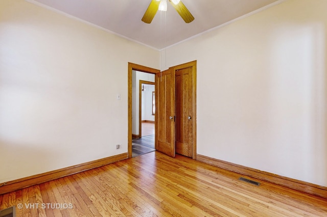 empty room featuring ceiling fan, crown molding, and light hardwood / wood-style flooring