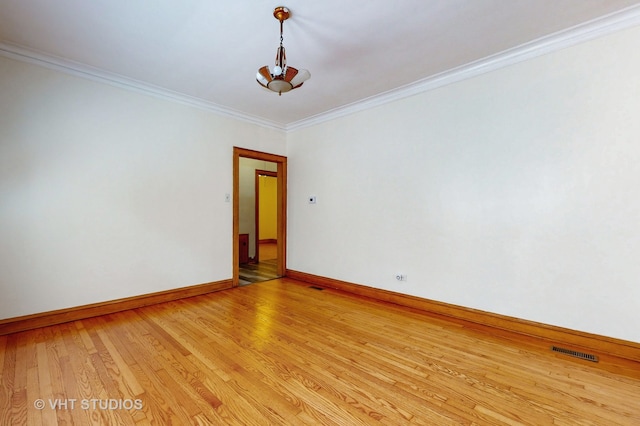 unfurnished room featuring ornamental molding, a chandelier, and light hardwood / wood-style floors