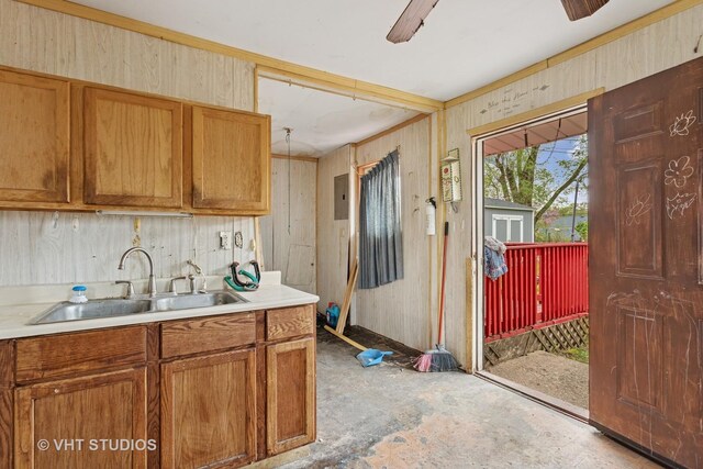 kitchen featuring light countertops, brown cabinetry, a sink, and concrete floors