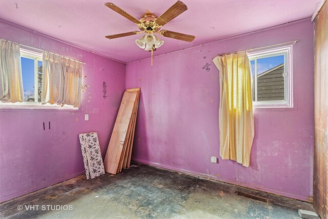 spare room with visible vents, ceiling fan, and unfinished concrete flooring