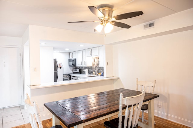 dining area with light hardwood / wood-style flooring, sink, and ceiling fan