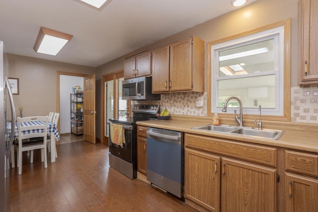 kitchen featuring a sink, stainless steel appliances, light countertops, decorative backsplash, and dark wood-style flooring