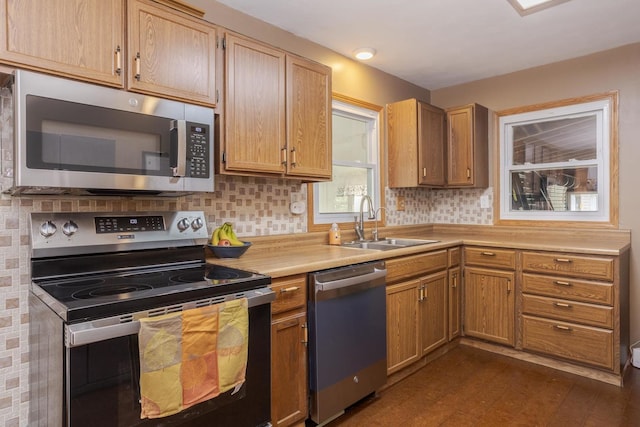 kitchen featuring a sink, appliances with stainless steel finishes, light countertops, decorative backsplash, and dark wood-style flooring