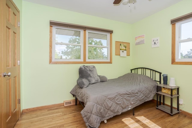 bedroom with visible vents, baseboards, light wood-style flooring, and a ceiling fan