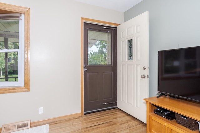 interior space featuring baseboards, visible vents, and light wood-type flooring