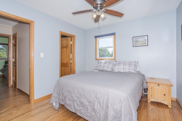 bedroom with light wood-style flooring, multiple windows, and baseboards