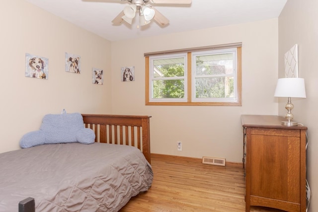 bedroom with a ceiling fan, visible vents, and light wood finished floors