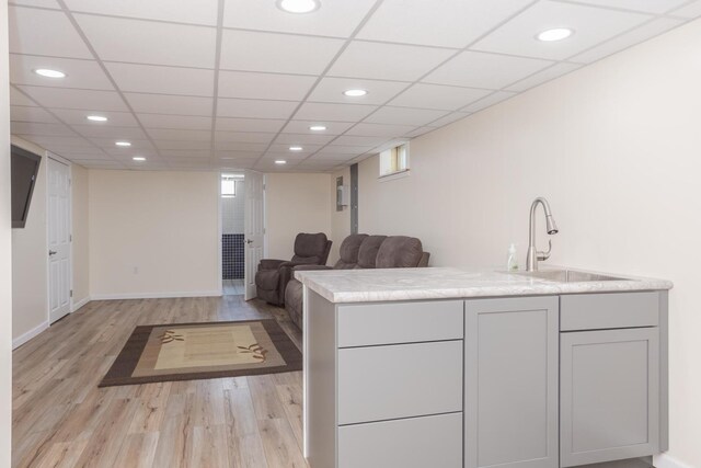 interior space featuring baseboards, recessed lighting, light wood-type flooring, and a sink