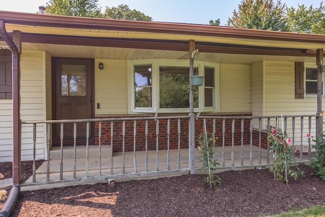 property entrance featuring a porch and fence