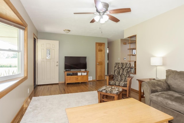 living room with visible vents, baseboards, and wood finished floors