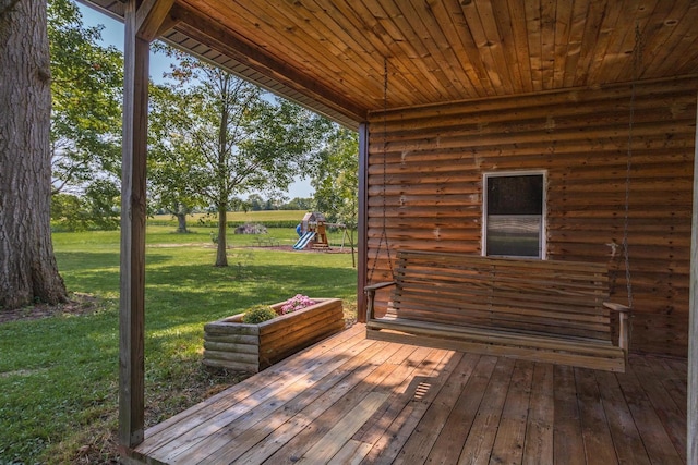 wooden deck with a playground and a yard