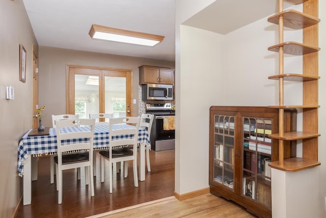 dining area with baseboards and light wood-type flooring