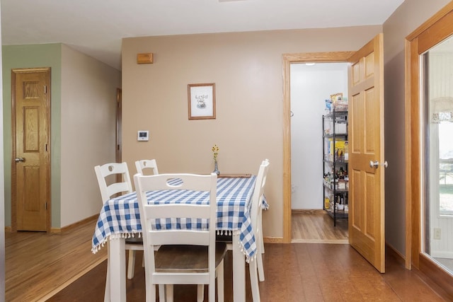 dining space featuring wood finished floors and baseboards