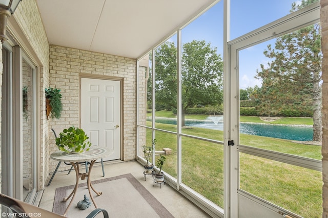 sunroom featuring a water view and a wealth of natural light