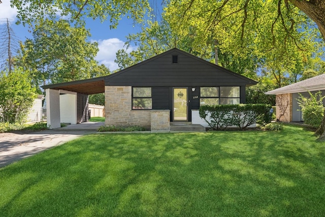 view of front of property featuring an attached carport, driveway, and a front lawn