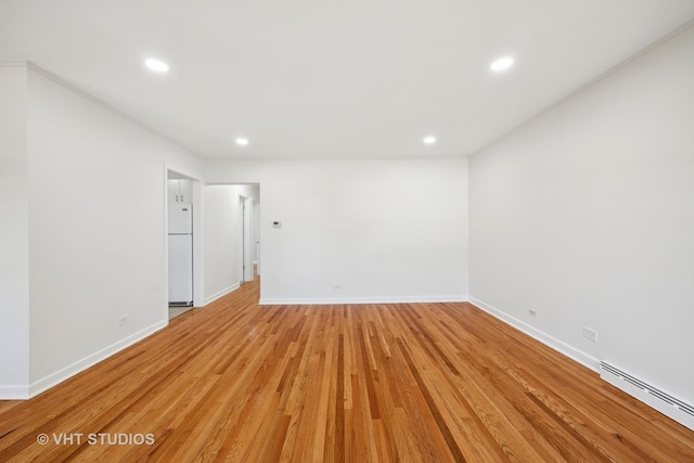 spare room featuring light wood-style floors, baseboards, a baseboard radiator, and recessed lighting