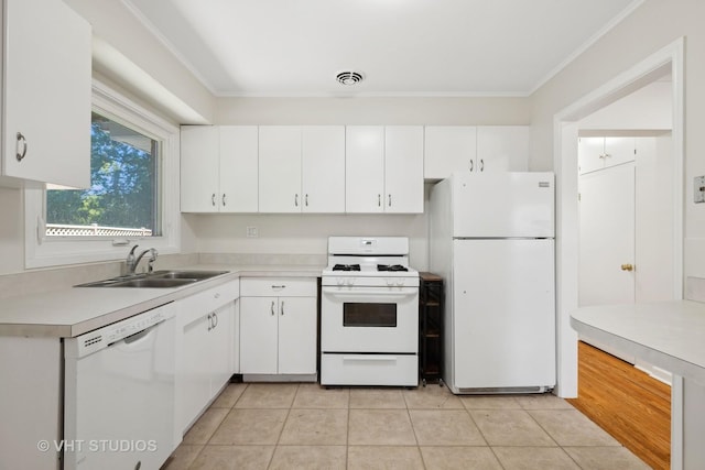 kitchen with crown molding, white appliances, light countertops, white cabinets, and a sink