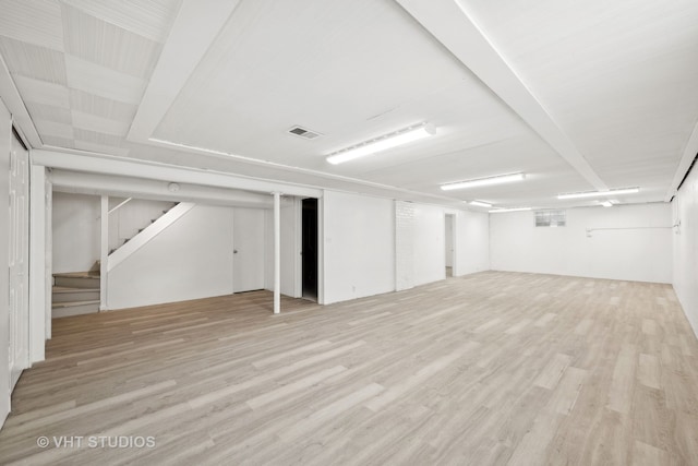 basement with light hardwood / wood-style flooring