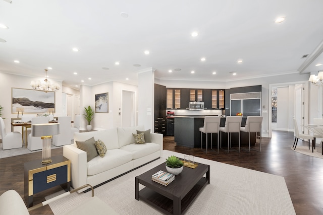 living room with dark hardwood / wood-style flooring, a notable chandelier, and ornamental molding