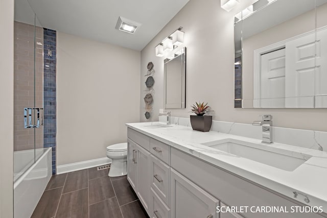 full bathroom with bath / shower combo with glass door, vanity, and toilet