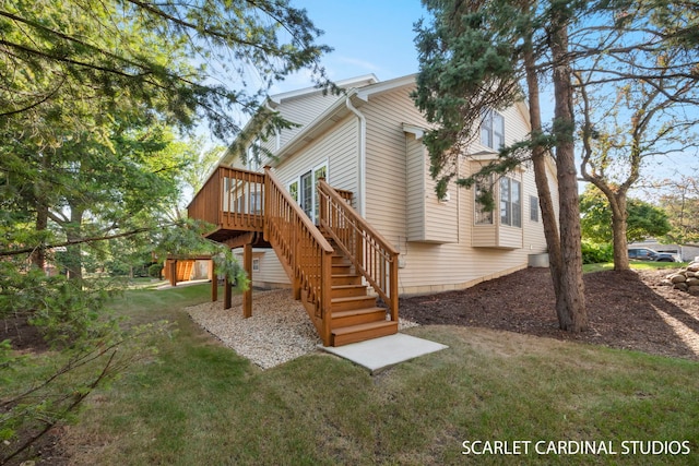 back of property with a wooden deck and a yard