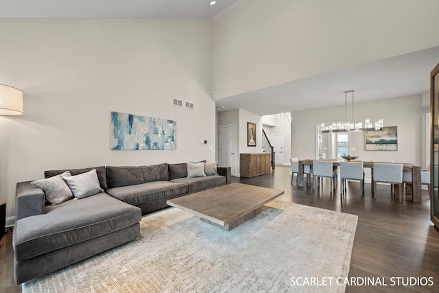 living room featuring a high ceiling, dark hardwood / wood-style floors, and a notable chandelier