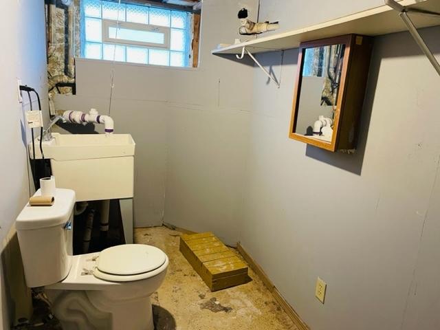 bathroom with concrete flooring and toilet