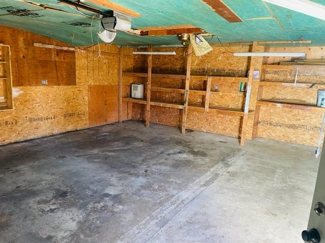 garage featuring a garage door opener and wood walls