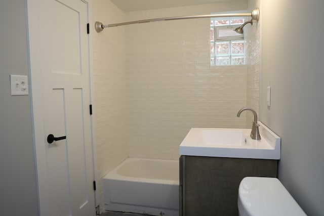 full bathroom with tiled shower / bath, vanity, and toilet