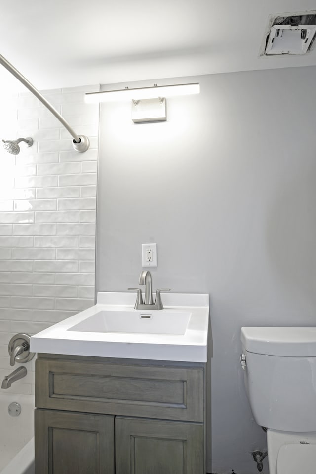 full bathroom featuring vanity, toilet, and tiled shower / bath