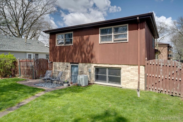 rear view of house featuring central air condition unit, a lawn, and a patio