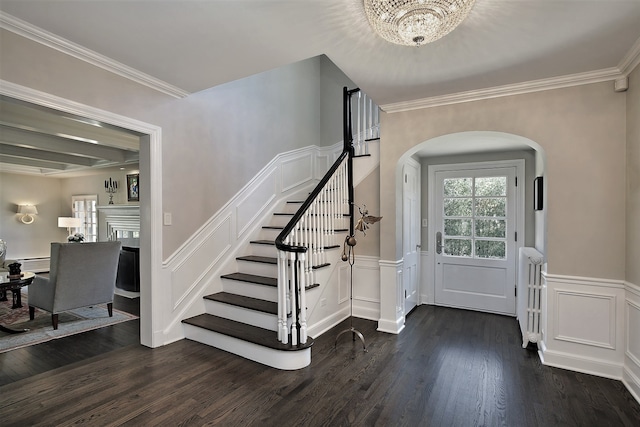 entryway with a notable chandelier, dark hardwood / wood-style floors, and crown molding