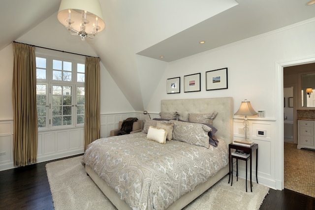 bedroom featuring an inviting chandelier, vaulted ceiling, ensuite bathroom, and dark hardwood / wood-style flooring