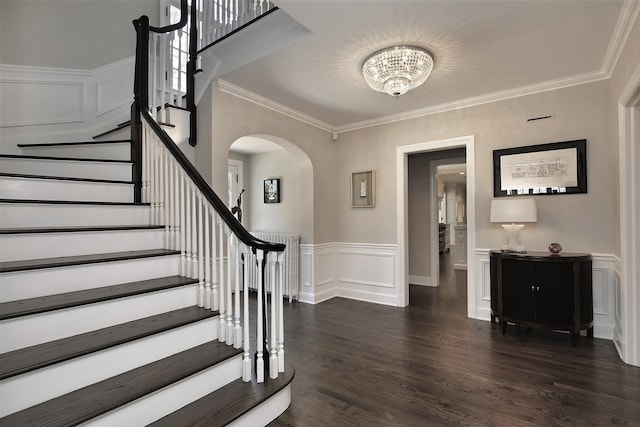 foyer entrance with crown molding, dark hardwood / wood-style flooring, radiator heating unit, and a chandelier