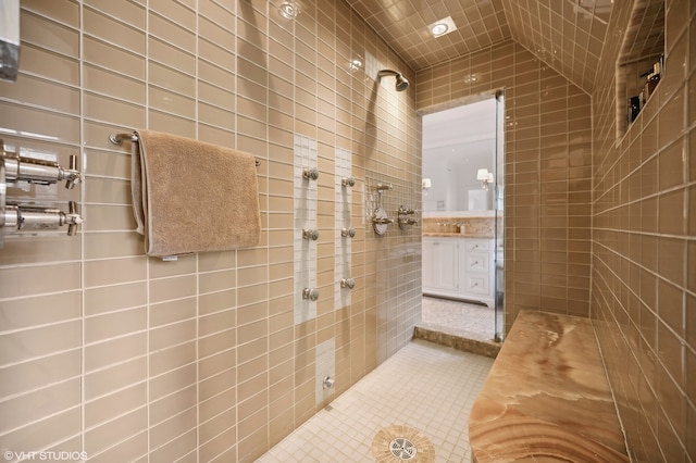 bathroom with vanity, tile walls, and tiled shower