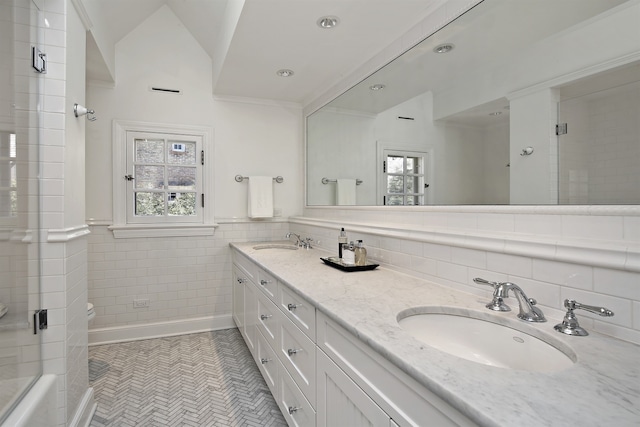 bathroom with tile walls, tile patterned flooring, lofted ceiling, walk in shower, and vanity