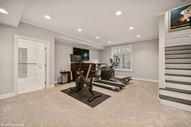 exercise room featuring crown molding and light colored carpet