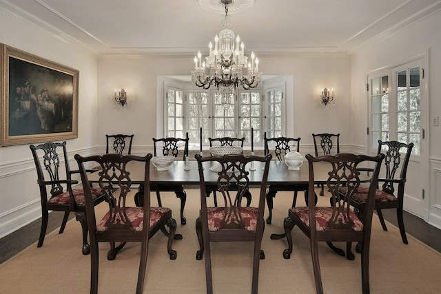 dining space with an inviting chandelier, hardwood / wood-style floors, and crown molding