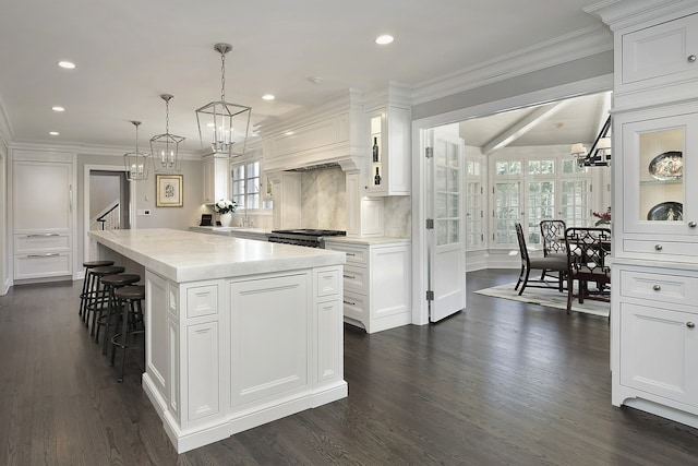 kitchen featuring a kitchen island, white cabinetry, dark hardwood / wood-style floors, and plenty of natural light