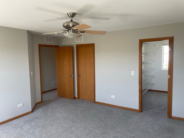 unfurnished bedroom with ceiling fan and light colored carpet