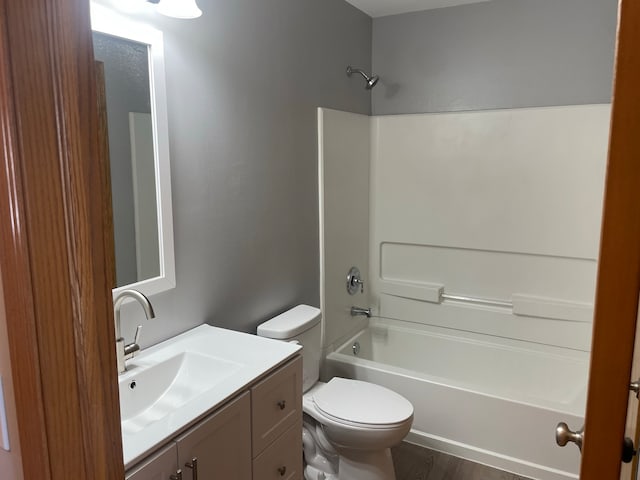 full bathroom with tub / shower combination, vanity, toilet, and hardwood / wood-style floors