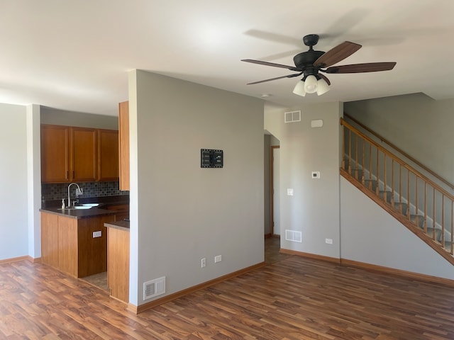 interior space with ceiling fan, sink, tasteful backsplash, and dark hardwood / wood-style flooring