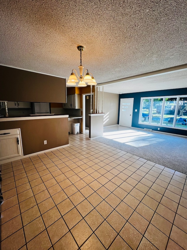 interior space with hanging light fixtures, an inviting chandelier, light carpet, and a textured ceiling