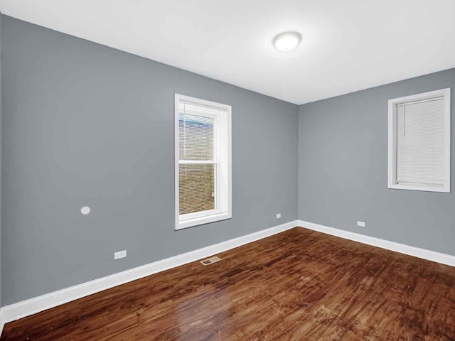 unfurnished room with dark wood-type flooring