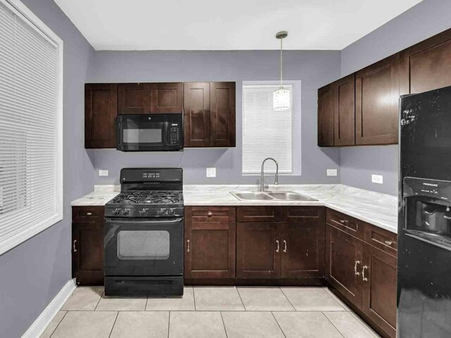 kitchen featuring black appliances, hanging light fixtures, sink, dark brown cabinetry, and light tile patterned flooring