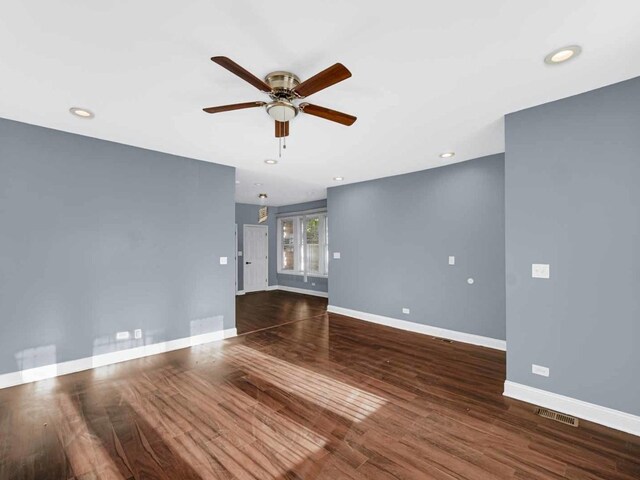 empty room featuring dark wood-type flooring and ceiling fan