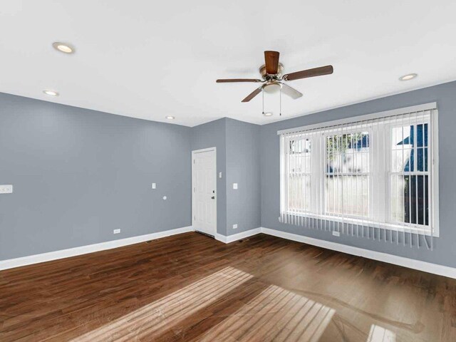 empty room with dark wood-type flooring and ceiling fan