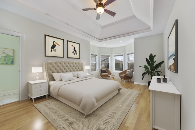 bedroom with a tray ceiling, light hardwood / wood-style flooring, ceiling fan, and ornamental molding