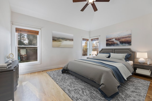 bedroom with vaulted ceiling, light hardwood / wood-style flooring, and ceiling fan