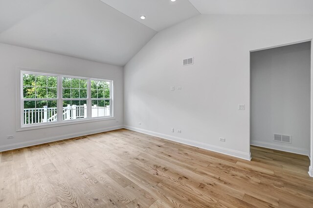 empty room featuring light hardwood / wood-style flooring and vaulted ceiling